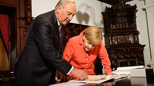 Bundeskanzlerin Angela Merkel und der lettische Präsident Andris Berzins unterhalten sich.