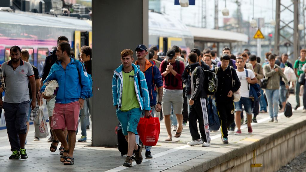 Flüchtlinge laufen auf dem Hauptbahnhof in München über einen Bahnsteig.