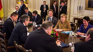 Chancellor Angela Merkel sits opposite Greek Prime Minister Antonis Samaras.