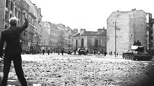 Ein Mann droht mit der Faust in die Richtung eines sowjetischen Panzers.