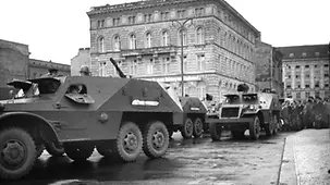 Eine Gruppe von Menschen beobachtet eine sowjetische Militärkolonne.