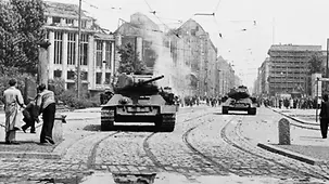 Demonstranten werfen Steine auf sowjetische Panzer.