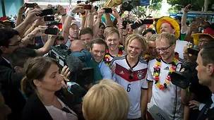 Bundeskanzlerin Angela Merkel trifft auf Fans der deutschen Fußball-Nationalmannschaft.
