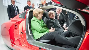 Angela Merkel and Vladimir Putin sit in the Volkswagen XL1.