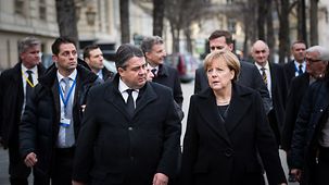 Bundeskanzlerin Angela Merkel geht neben Wirtschaftsminister Gabriel.