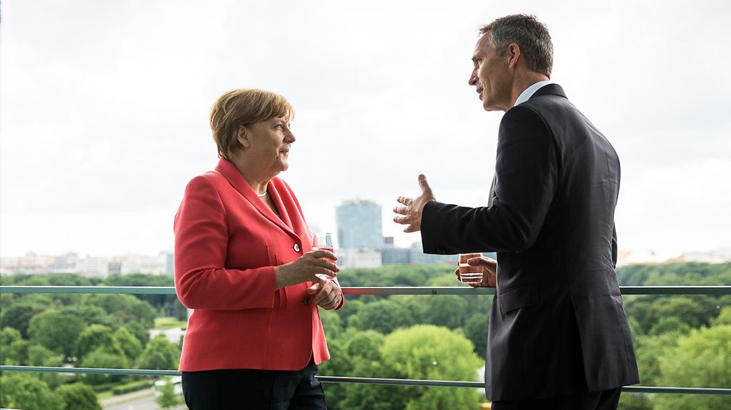 Chancellor Angela Merkel talking to NATO Secretary General Jens Stoltenberg on the Federal Chancellery balcony