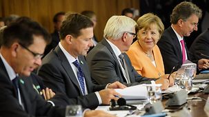 Bundeskanzlerin Angela Merkel sitzt in der Plenarsitzung neben Außenminister Frank-Walter Steinmeier.