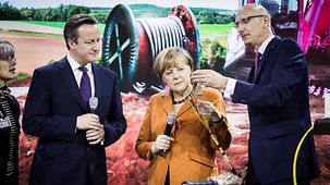 Bundeskanzlerin Angela Merkel mit Premier David Cameron am Telekom-Stand mit Vorsitzendem Timotheus Höttges.