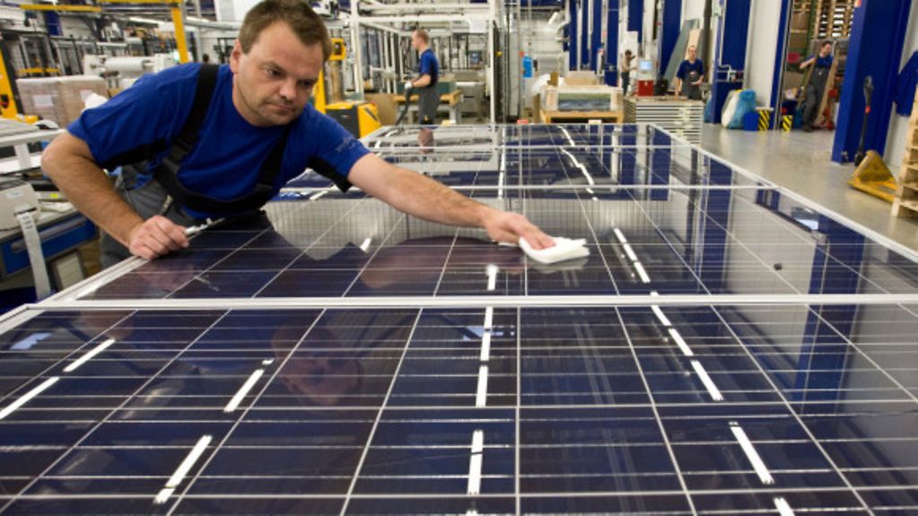 Mitarbeiter säubert die fertigen Solarmodule.