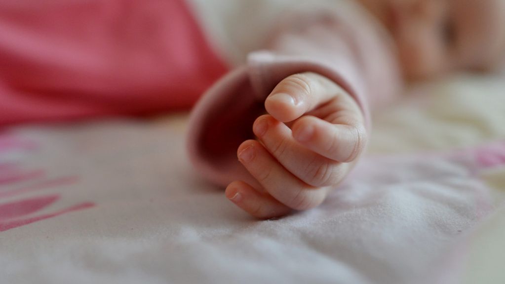 Die Hand von einem Neugeborenen
