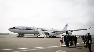 Journalists walk towards an airplane at Tegel airport