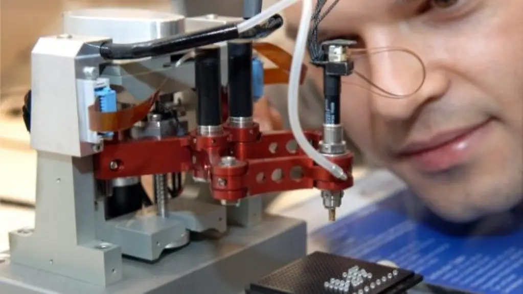 Ein Mitarbeiter des Zentrums für Mikroproduktion in Braunschweig betrachtet einen Präzisionsroboter