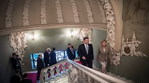 Chancellor Angela Merkel and the Ukrainian President Petro Poroshenko walk up the stairs.
