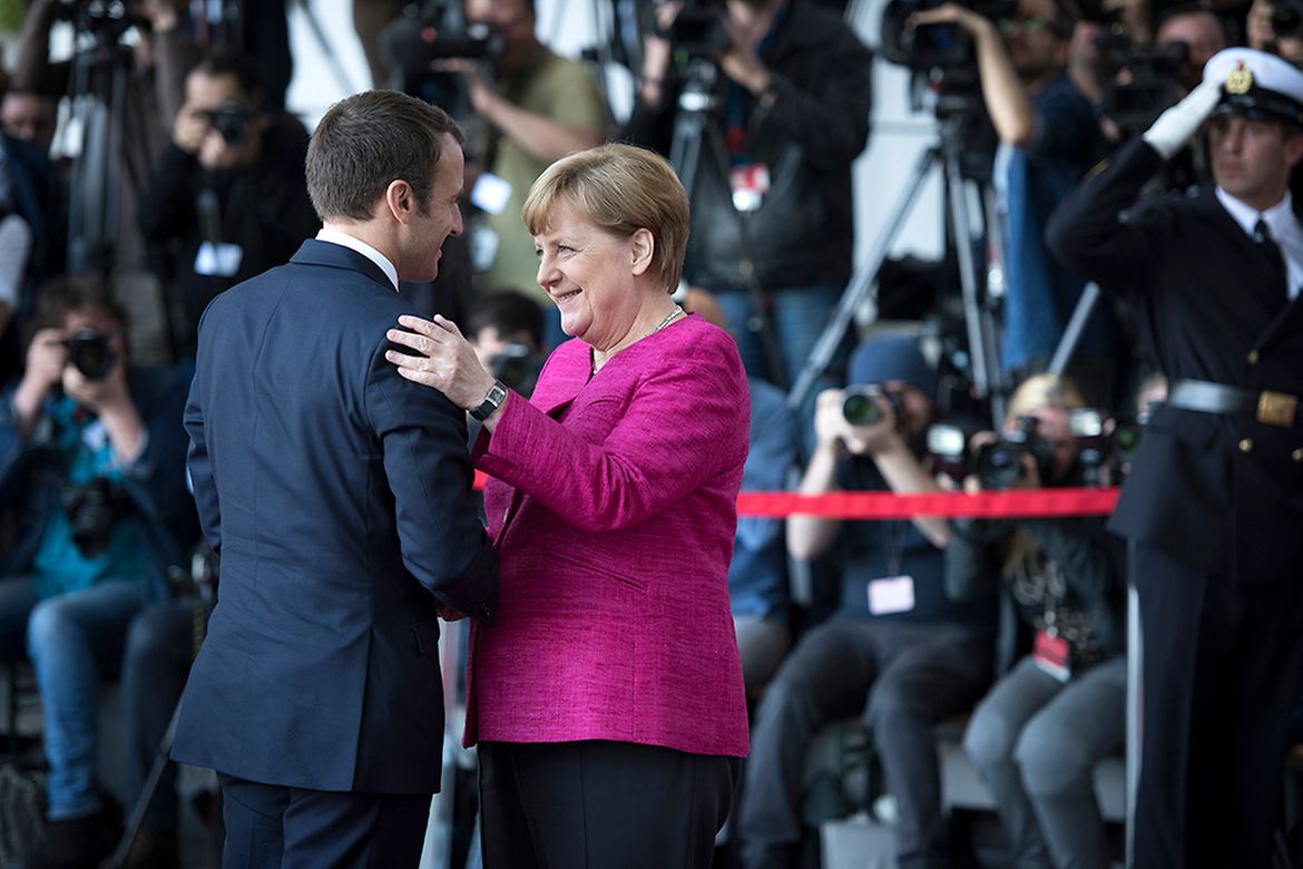 Chancellor Angela Merkel greets French President Emmanuel Macron at the Federal Chancellery.