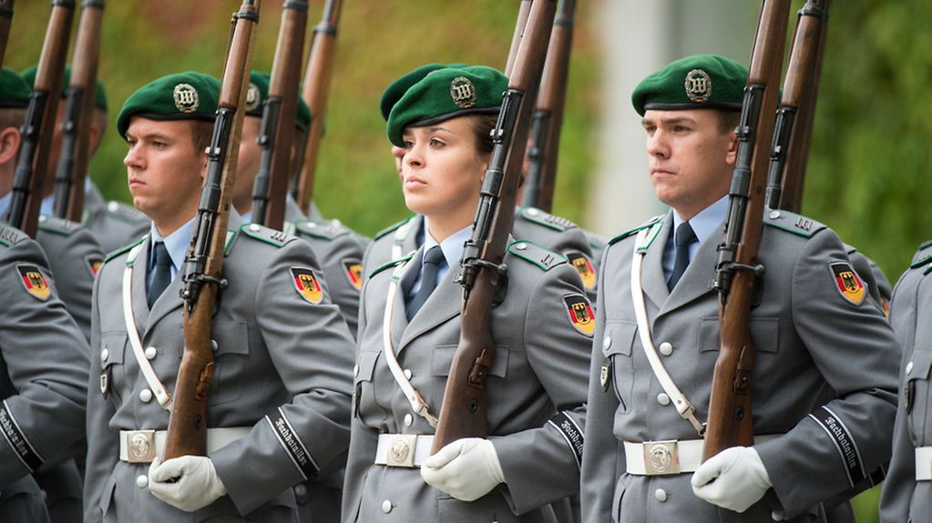Eine Soldatin und mehrere Soldaten des Wachbataillons der Bundeswehr stehen am 28.08.2015 vor dem Bundeskanzleramt in Berlin