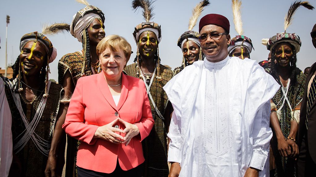 Bundeskanzlerin Angela Merkel wird bei der Ankunft in Niger vom Präsidenten Issoufou Mahamadou begrüßt.
