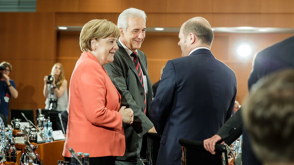 Chancellor Angela Merkel talks to Saxony's Premier Stanislaw Tillich and Hamburg' First Mayor Olaf Scholz.