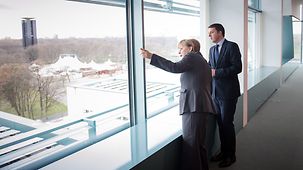 Bundeskanzlerin Angela Merkel schaut mit dem italienischen Ministerpräsidenten Matteo Renzi aus einem Fenster des Kanzleramtes.