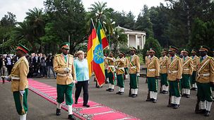 Bundeskanzlerin Angela Merkel schreitet beim Empfang mit militärischen Ehren die Ehrengarde ab.