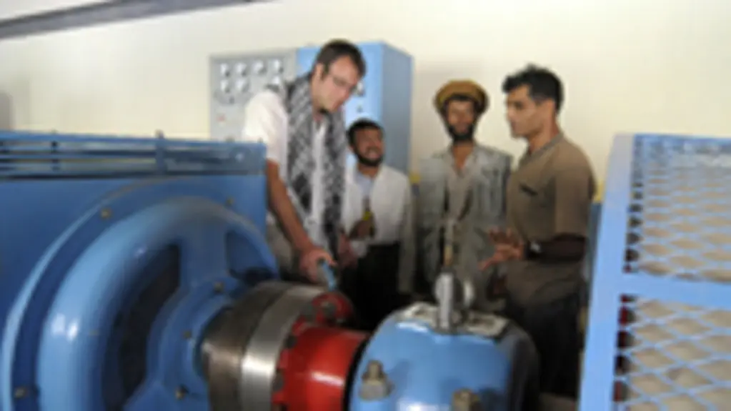 BEntwicklungshelfer erklären eine neue Turbine in einem afghanischen Wasserkraftwerk.