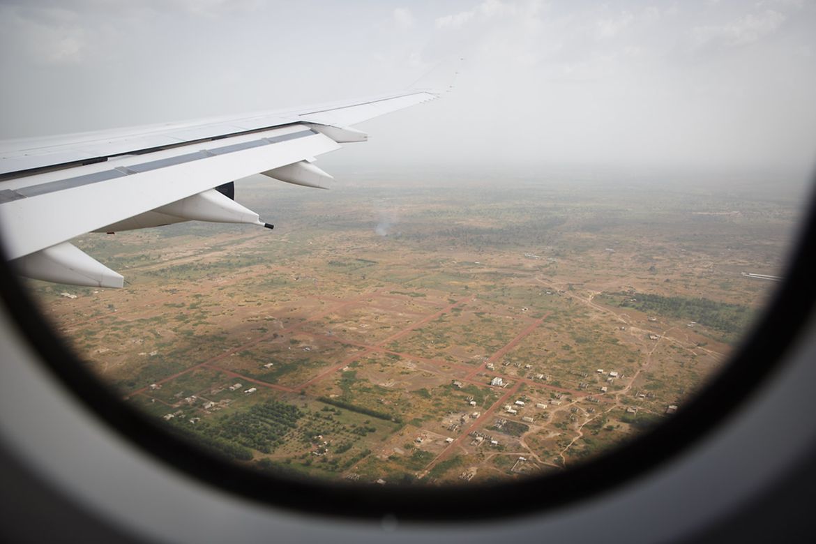Blick aus dem Fenster eines Flugzeuges auf einen Landesteil Afrikas.