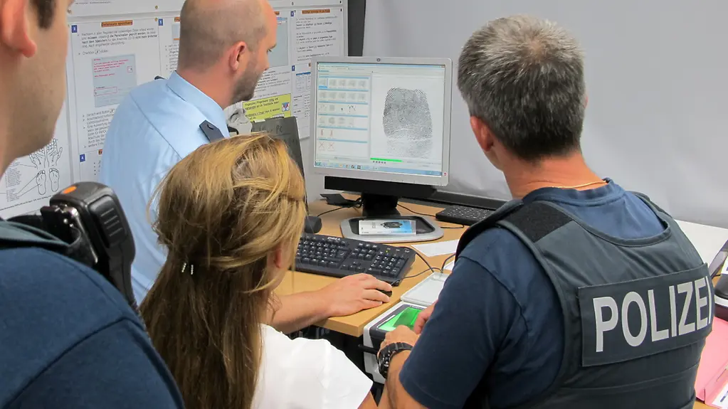 Einer albanischen Frau werden die Fingerabdrücke von der Bundespolizei digital abgenommen.