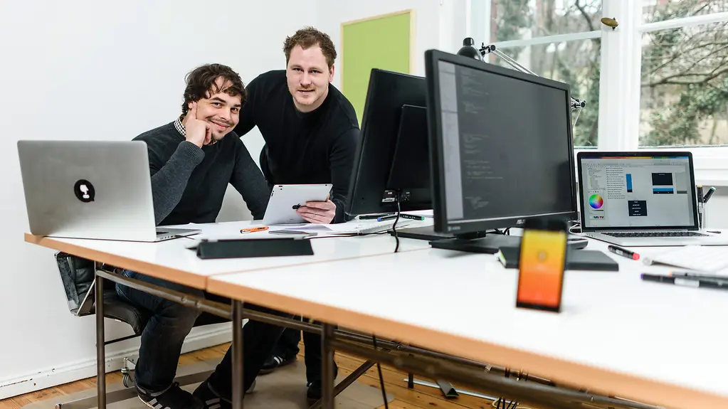 Zwei junge Männer, die Apps für Smartphones entwickeln