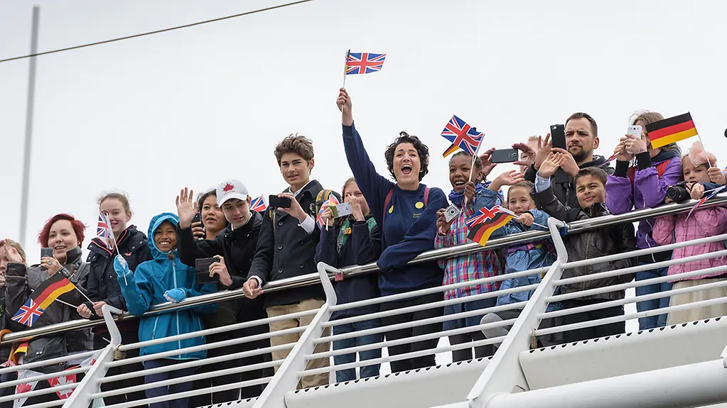 Cheering crowds welcome the Queen.