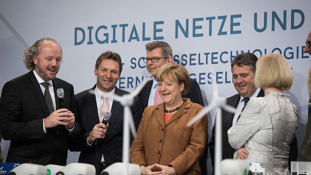Bundeskanzlerin Angela Merkel lässt sich beim IT-Gipfel den intelligenten Handschuh "ProGlove" erklären.