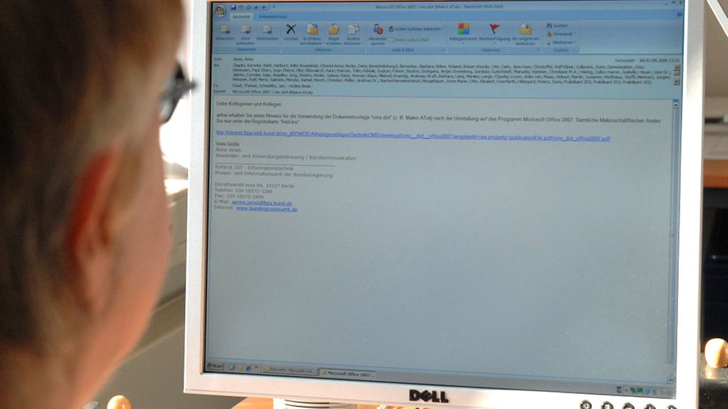 Eine Frau hinter dem PC beim Formulieren einer E-Mail.