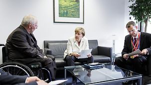Bundeskanzlerin Angela Merkel unterhält sich mit Wolfgang Schäuble, Bundesminister der Finanzen.