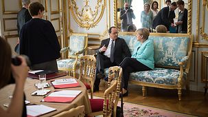 Bundeskanzlerin Angela Merkel spricht mit dem französischen Präsidenten François Hollande.