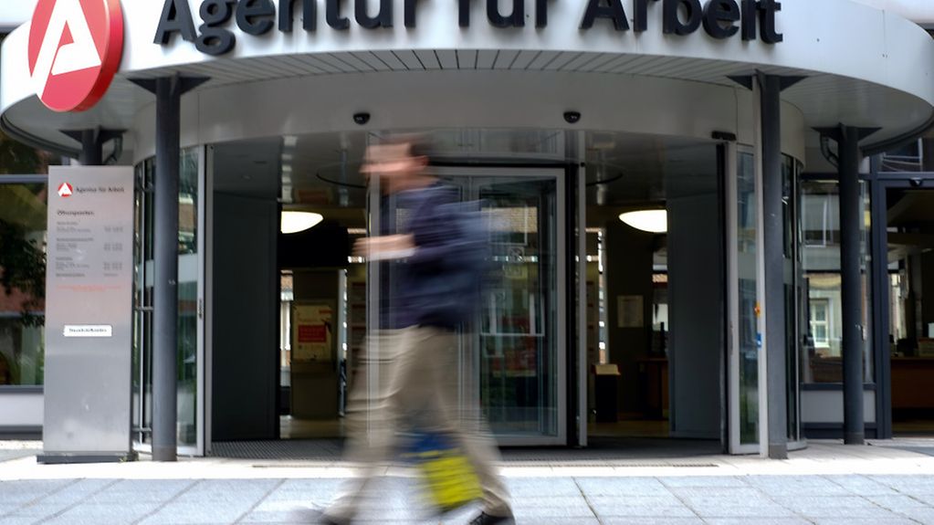 A man walks past an Employment Agency in Hamburg.