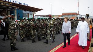 La chancelière fédérale Angela Merkel et le président de la République du Mali, Ibrahim Boubacar Keita, passent devant les soldats en formation lors de l’accueil avec les honneurs militaires