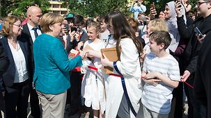 Bundeskanzlerin Angela Merkel trifft anlässlich des EU-Projekttages in der Kurt-Tucholsky-Oberschule ein und wird von Schülerinnen und Schülern begrüßt.