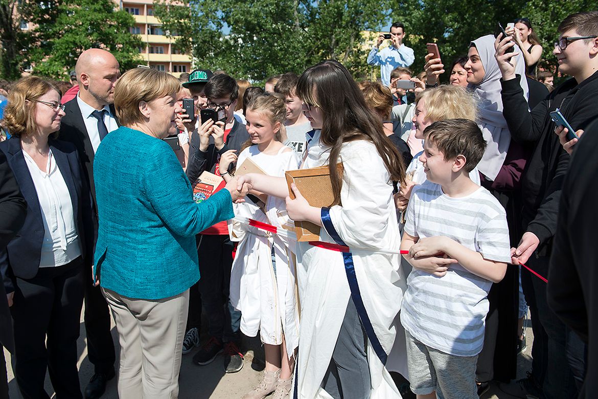 Bundeskanzlerin Angela Merkel trifft anlässlich des EU-Projekttages in der Kurt-Tucholsky-Oberschule ein und wird von Schülerinnen und Schülern begrüßt.