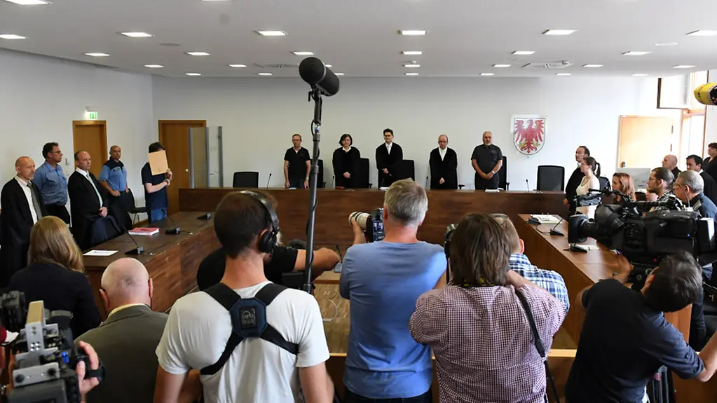 Journalisten stehen im Gerichtssaal.