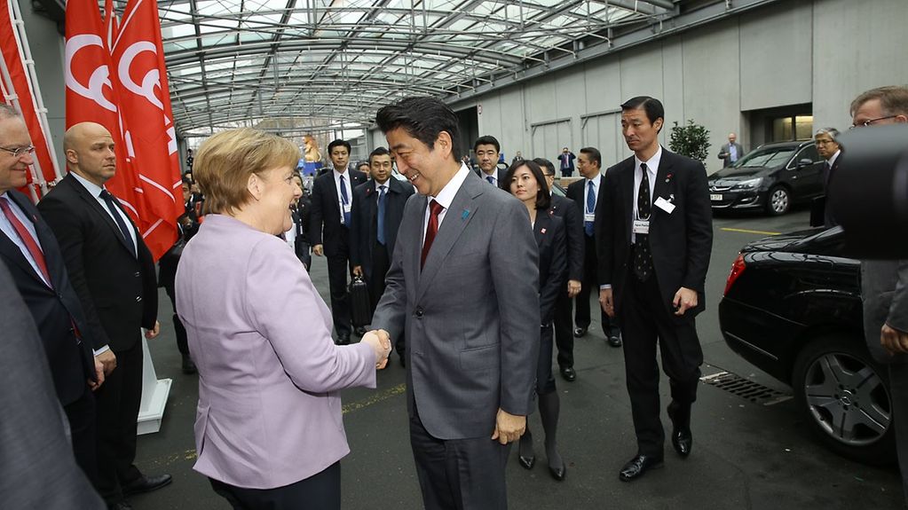 Chancellor Angela Merkel greets Japanese Prime Minister Shinzo Abe before they tour CeBIT together.