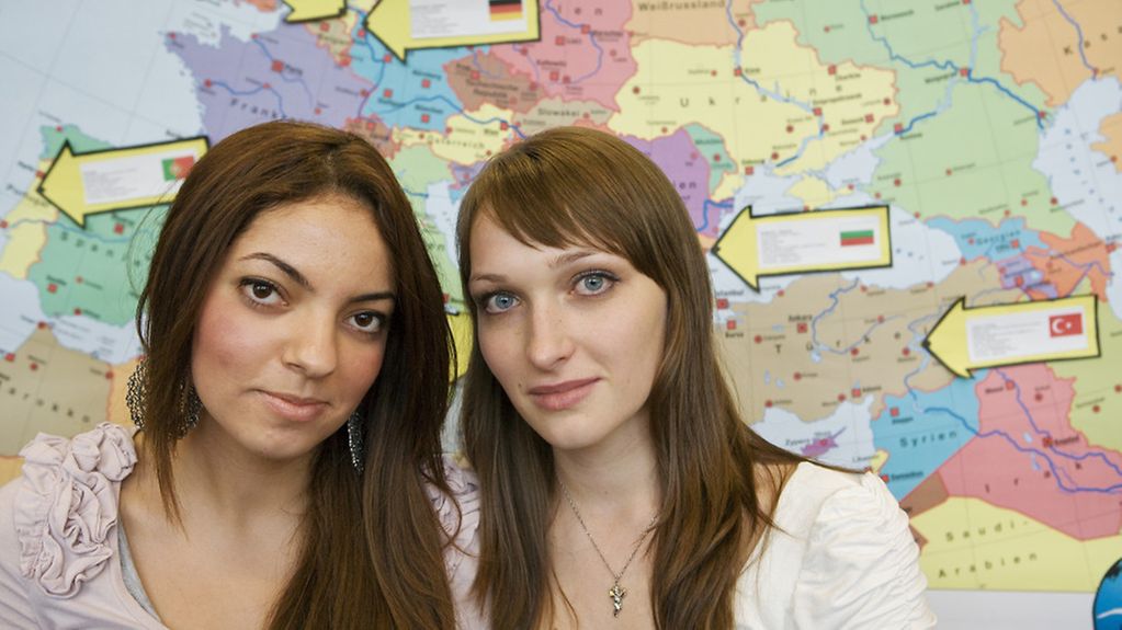 zwei junge Frauen vor einer Landkarte