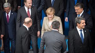 Bundeskanzlerin Angela Merkel nimmt für das Familienfoto Aufstellung.