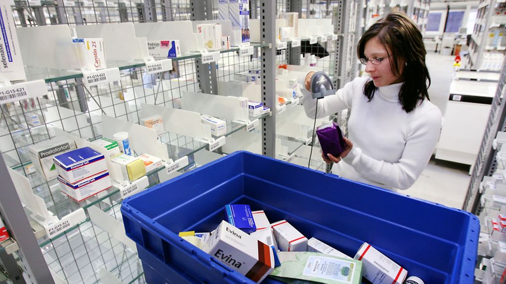Logistikmitarbeiterin vor einem Regal in einem Arzneimittellager.