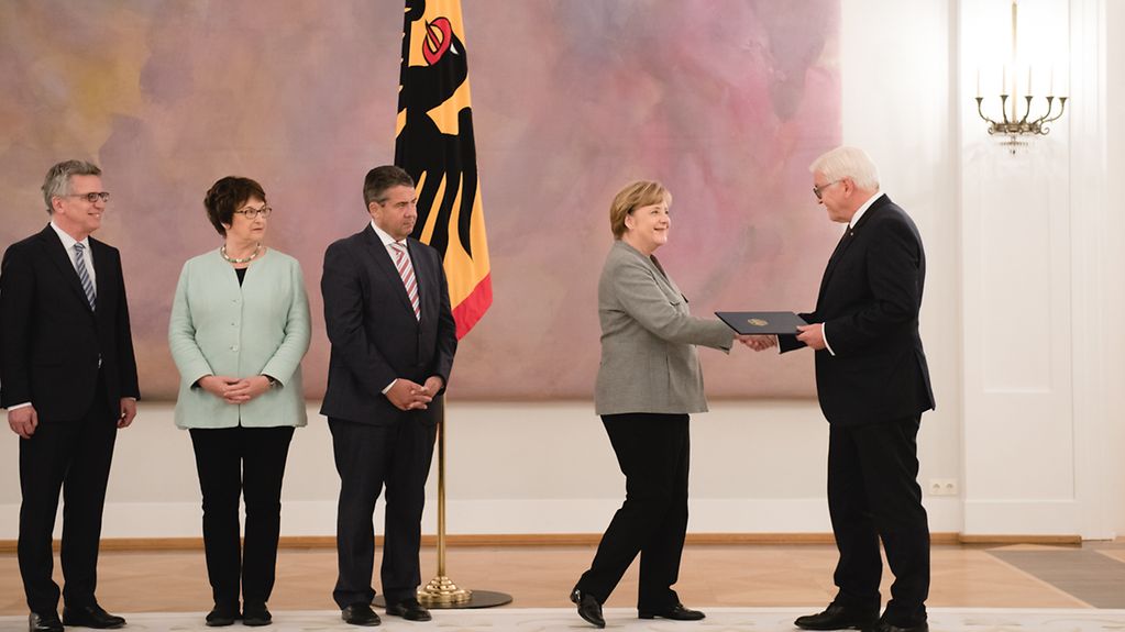 Bundespräsident Frank-Walter Steinmeier übergibt Bundeskanzlerin Angela Merkel die Entlassungsurkunde.