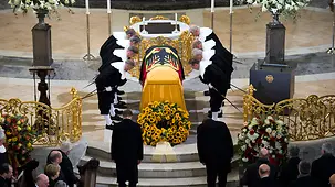 The coffin bearers bow.