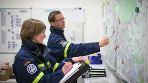 Tina Mühle und Kollege betrachten die Einsatzkarte des Ortsverbandes