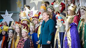 Bundeskanzlerin Angela Merkel inmitten der Sternsinger.