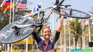 Denise Schindler hebt vor Freude ihr Fahrrad in die Höhe.