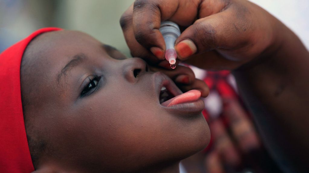Ein nicht identifizierter Gesundheitsbeamter verwaltet einen Polio-Impfstoff an ein Kind in Kawo Kano, Nigeria