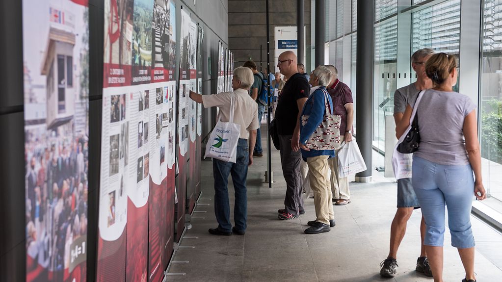 Besucher im Bundespresseamt vor einer Ausstellung.