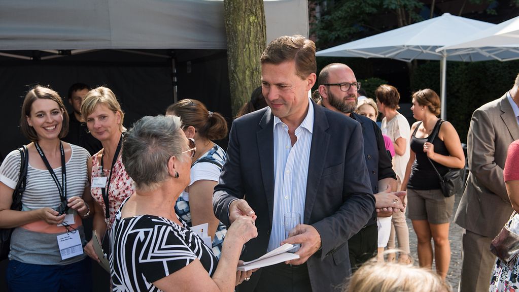 Regierungssprecher Steffen Seibert im Gespräch mit einer Besucherin im BPA.