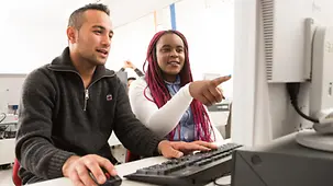 Die Schüler Omid Rezai und Susan Namutebi beim Unterricht am Computer.